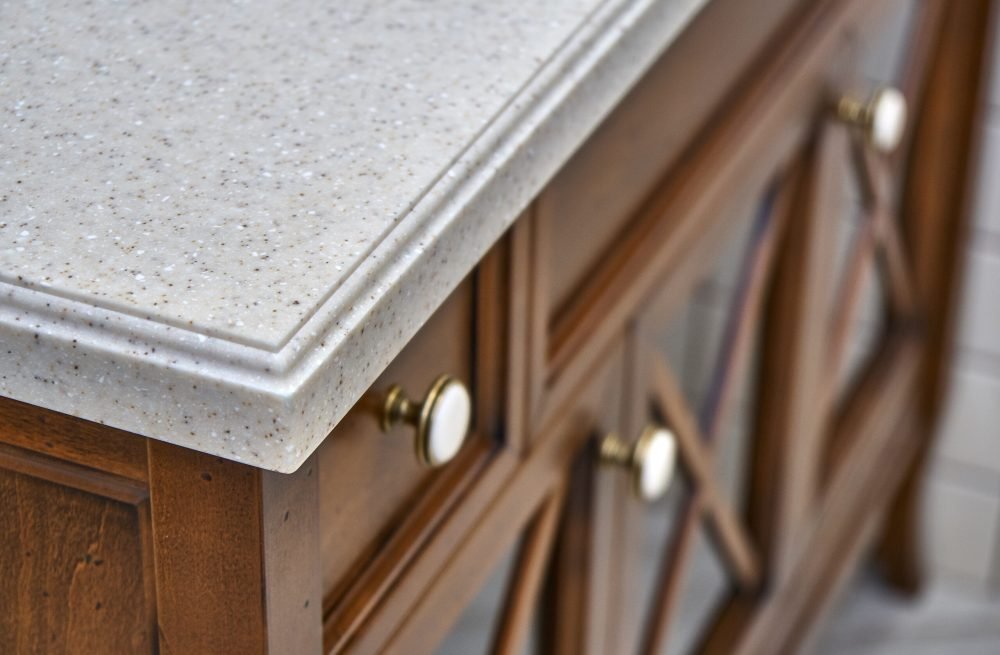 Elegant bathroom vanity cabinet with acrylic countertop located near tiled wall inside luxury water closet. Country style. Details furniture. Close-up